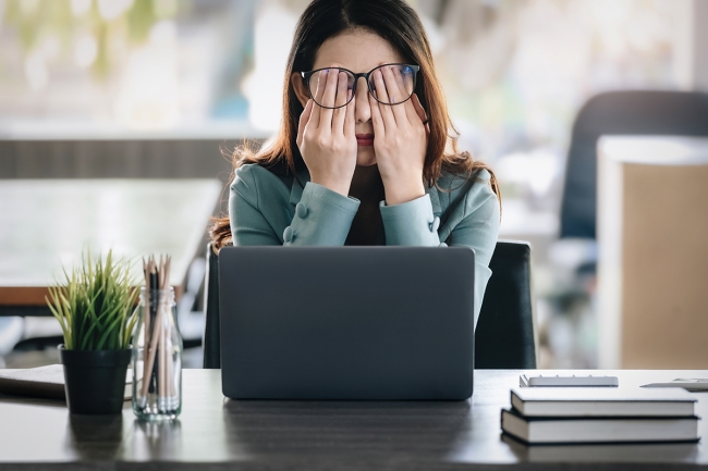 A distressed student rubs her eyes