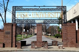 A brick gateway reads "Fisk University" in large, gold letters.