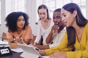 Diverse group of four students sitting together and working on a computer