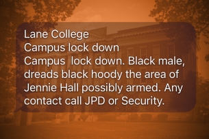 An image of the text alert sent to Lane College students superimposed on a photo of a campus building. The text message reads, "Lane College Campus lock down, Campus lock down. Black male, dreads black hoody the area of Jennie Hall possibly armed. Any contact call JPD or Security."