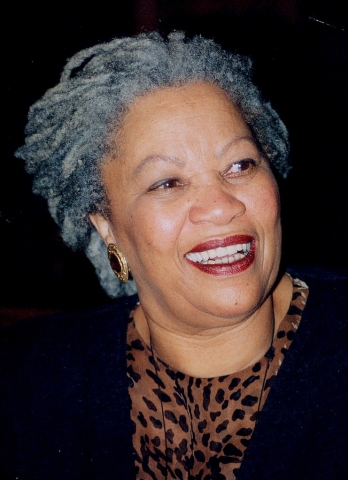 Photo of a smiling, gray-haired woman with a black jacket and leopard print shirt.