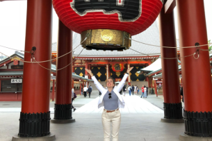 Leeza Fernand, an administrator at Northern Virginia community college, stands below a large, red lantern with her arms outstretched.