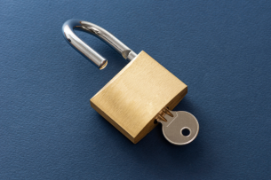 A key in an open padlock.